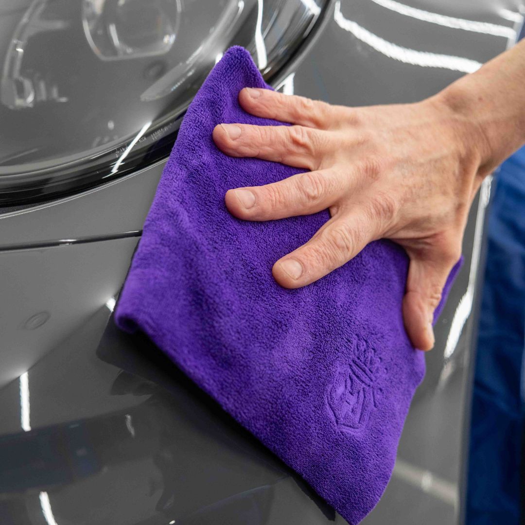 Person using Labocosmetica IDEALE microfibre to wipe Labocosmetica Armorius PPF Surface Reset on grey car.
