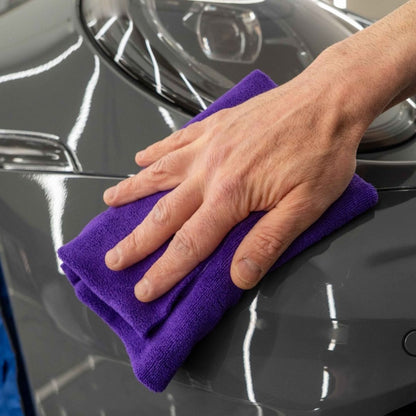 Person using Labocosmetica IDEALE microfibre to wipe Labocosmetica Armorius PPF Surface Reset on grey car.