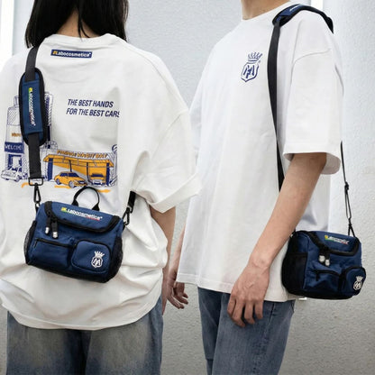 Two people wearing white t-shirts with branded logos and carrying blue bags. Labocosmetica Conibag - Detailing Shoulder Bag (Size S)