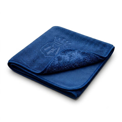A folded dark blue microfibre Labocosmetica Drying Towel with a plush sherpa lining and an embossed crown logo on the front, shown on a clean white background.
