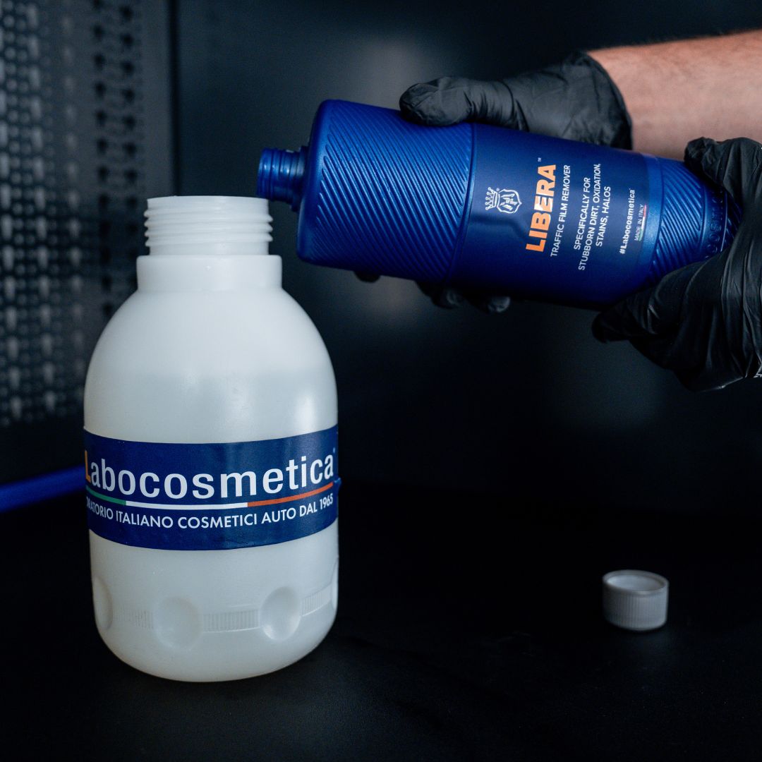 Person pouring Libera product into a Labocosmetica container with a dark background