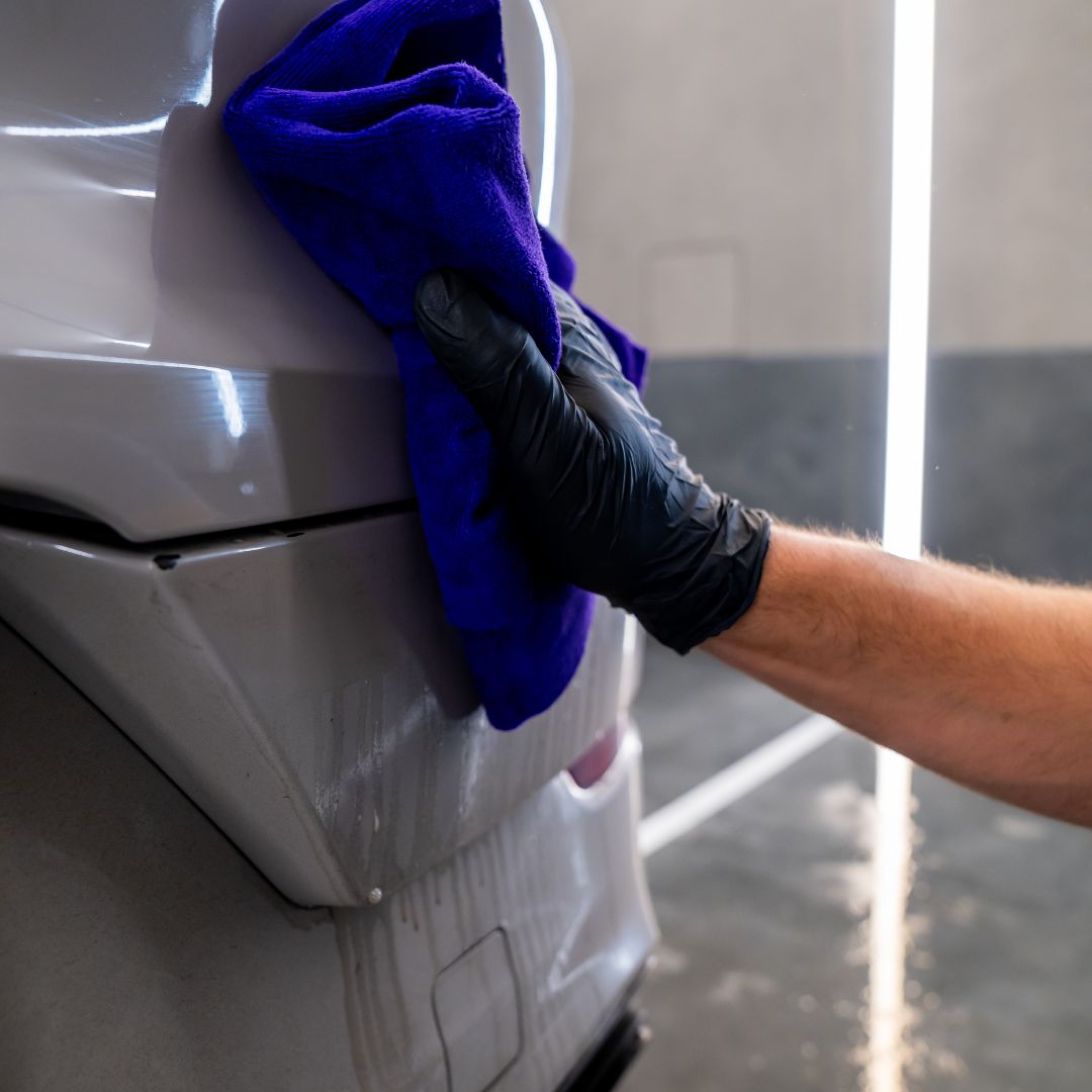 Person cleaning PPF with a blue microfiber towel