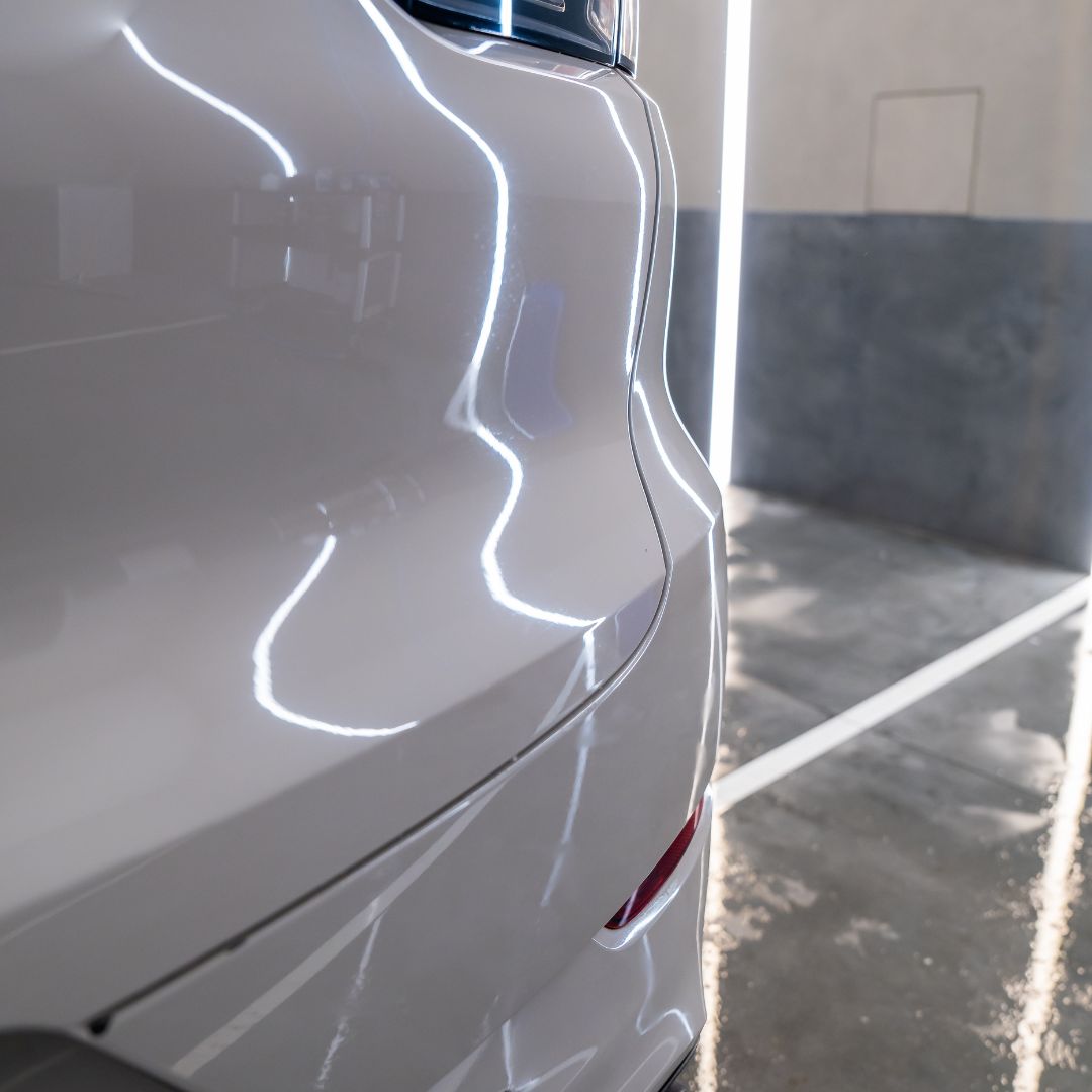 Close-up of a white car's side profile with a blurred background