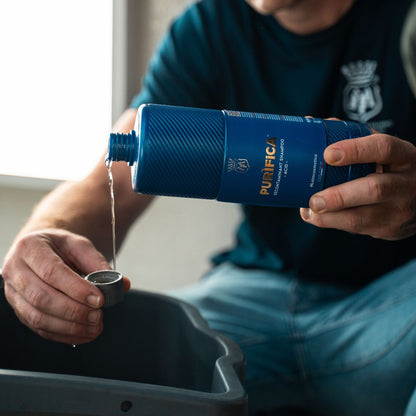Person pouring Labocosmetica Purifica Acid Shampoo from a bottle into a bucket.