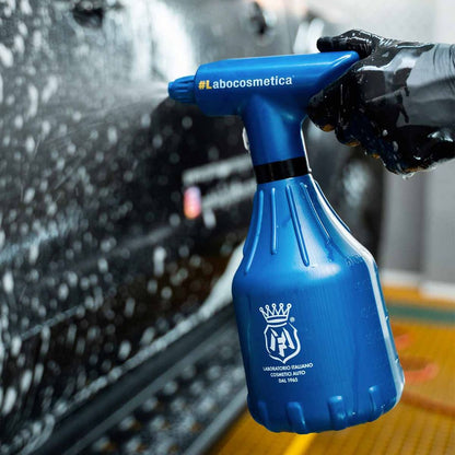 Labocosmetica Spray bottle applying Labocosmetica Purifica on a black car.