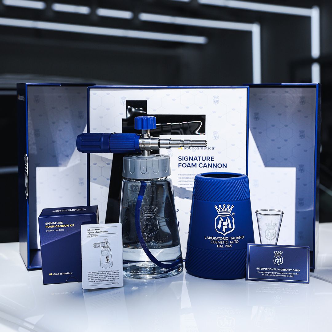 Labocosmetica Signature Foam Cannon kit displayed on a reflective white surface with its blue and white packaging boxes, instruction sheet, branded foam cup, small glass, and business card.