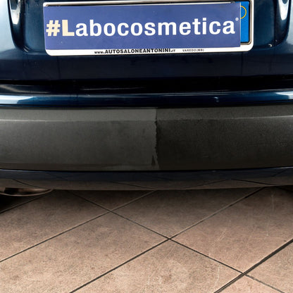 Car with a '#Labocosmetica' license plate on a tiled floor