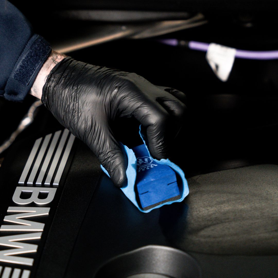 Person applying Labocosmetica TPR trim dressing on BMW engine cover