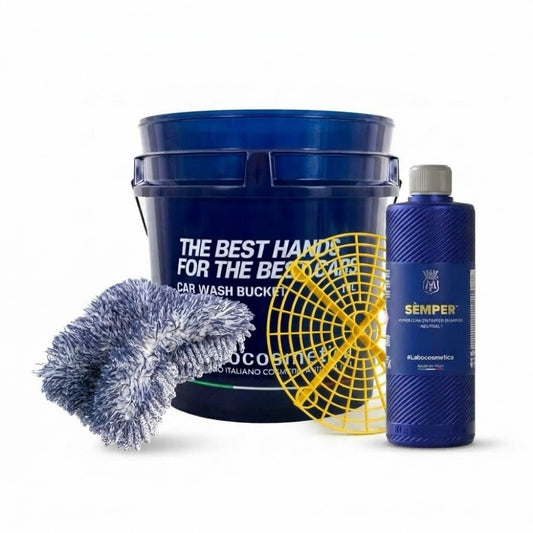 Car wash bucket kit with a large blue bucket, a blue bottle of Sémper neutral shampoo, a yellow grit guard, and a blue microfiber wash mitt on a white background.