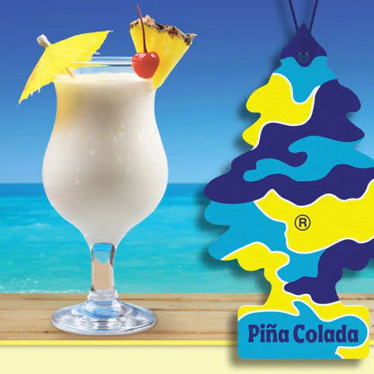 Pina Colada cocktail with pineapple wedge and cherry on a beach background, featuring a Little Trees Pina Colada branded car air freshener.