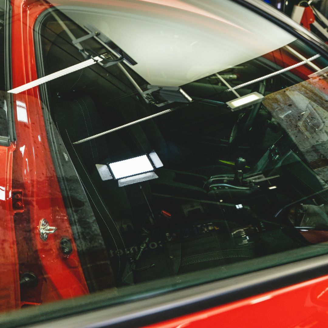 Close-up of a red car's interior with a focus on the door and window.