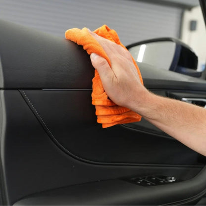Maniac Interior Quick Detailer sprayed on an orange microfibre cloth cleaning car door