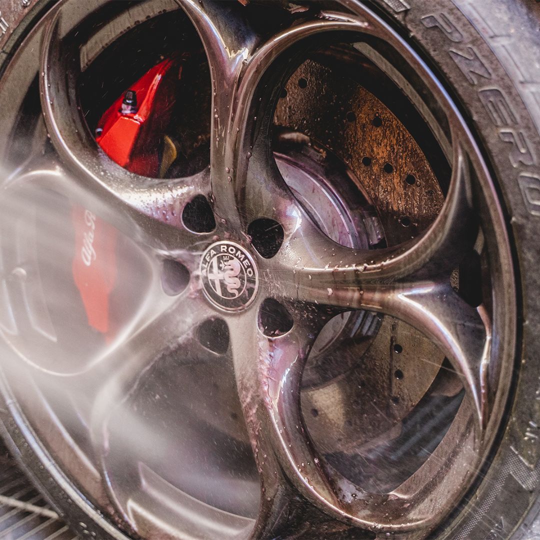 Close-up of a car wheel with a visible Alfa Romeo logo.