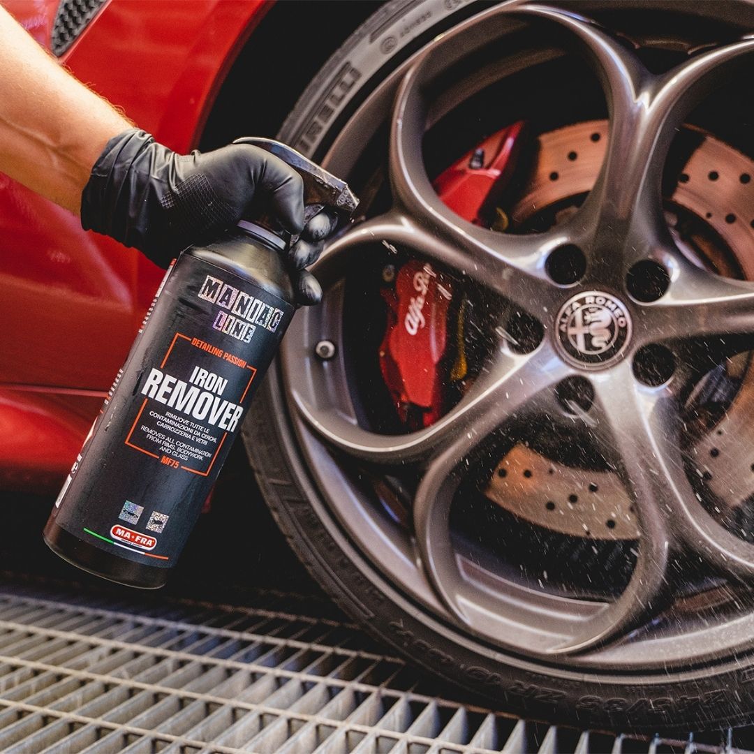 Person using a can of Manta Line Iron Remover on an Alfa Romeo wheel.