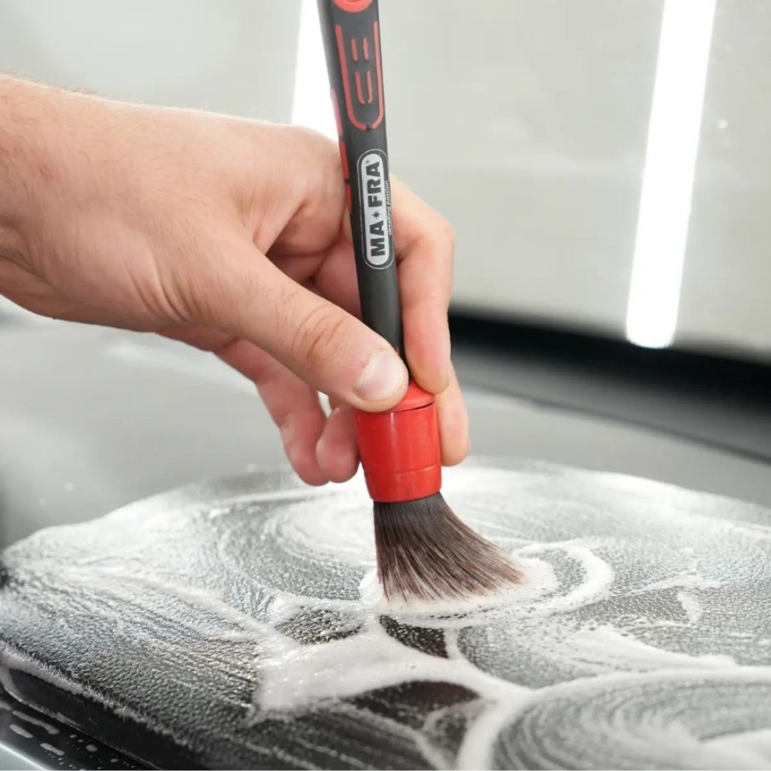 Maniac Multisurface Cleaner with brush on car dashboard