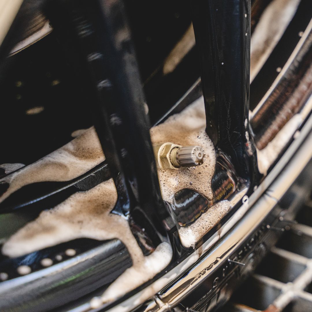 Close-up of a car wheel with soap suds on the rim