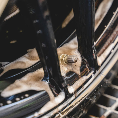 Close-up of a car wheel with soap suds on the rim