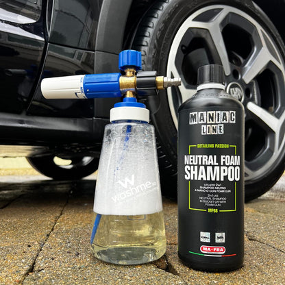 Car cleaning equipment with a bottle of Maniac Line Neutral Foam Shampoo next to a car wheel.