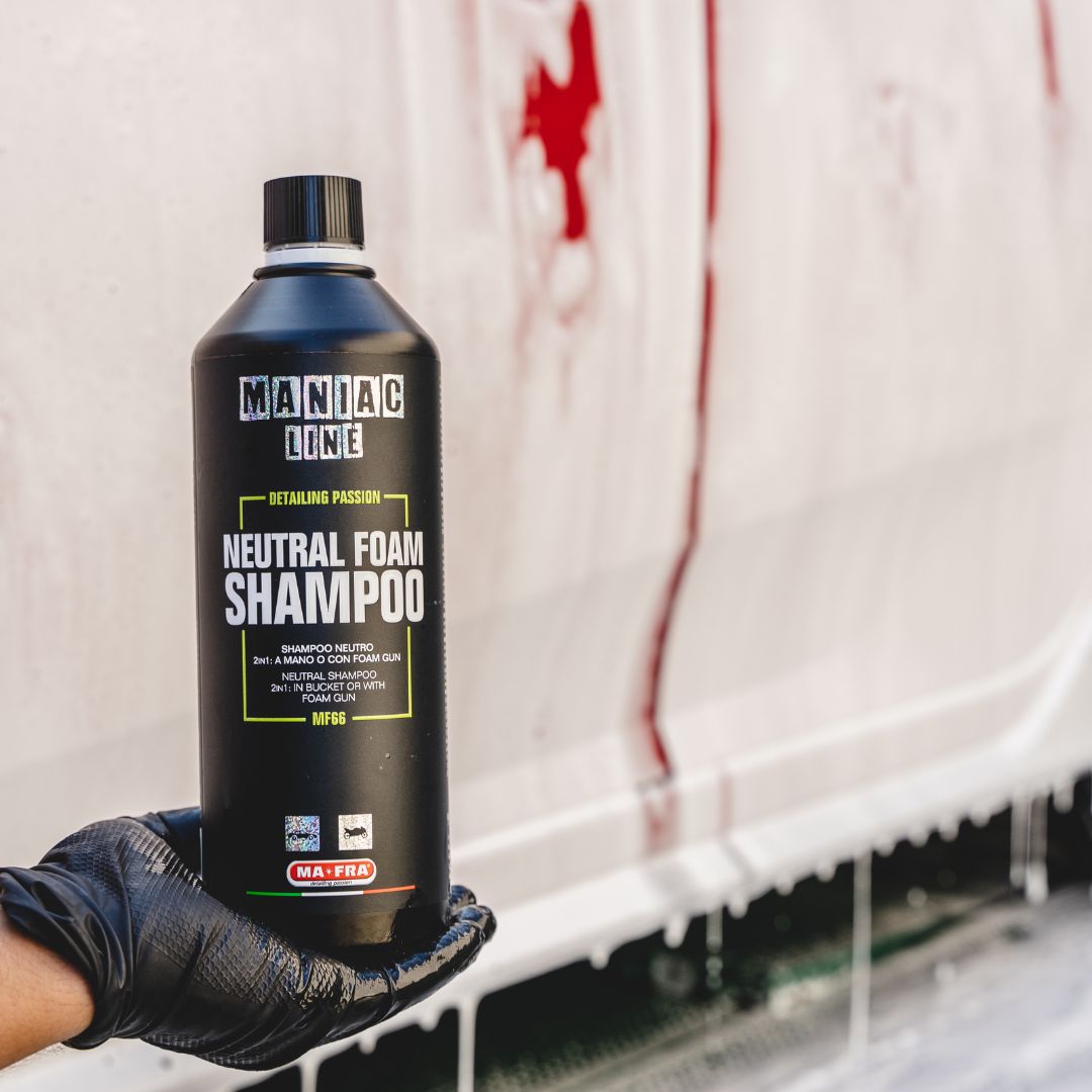 Maniac Line Neutral Foam Shampoo bottle held by a gloved hand with a car wash background.