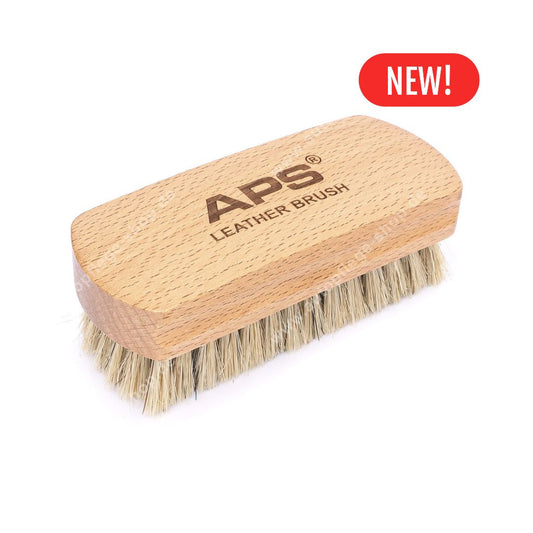 A wooden leather brush with natural wood handle and beige bristles, featuring the brand name 'APS' and 'LEATHER BRUSH' printed on the top. A red 'NEW!' badge is shown in the upper right corner against a plain white background.