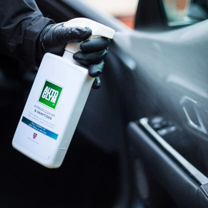 Person holding a bottle of AAutoglym Interior Cleaner & Sanitiser inside a car.