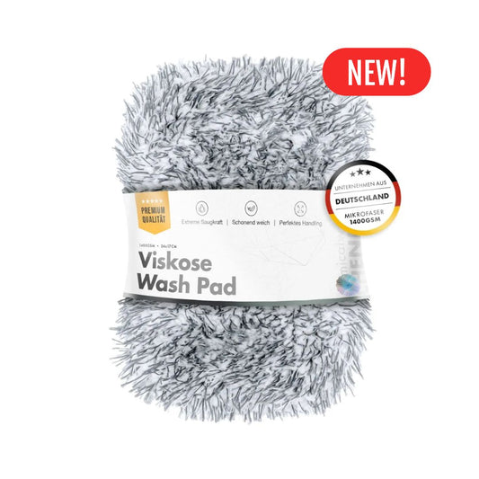 A fluffy gray and white plush wash pad wrapped in a white paper band labeled 'Viskose Wash Pad,' with a red 'NEW!' badge in the top right on a white background.