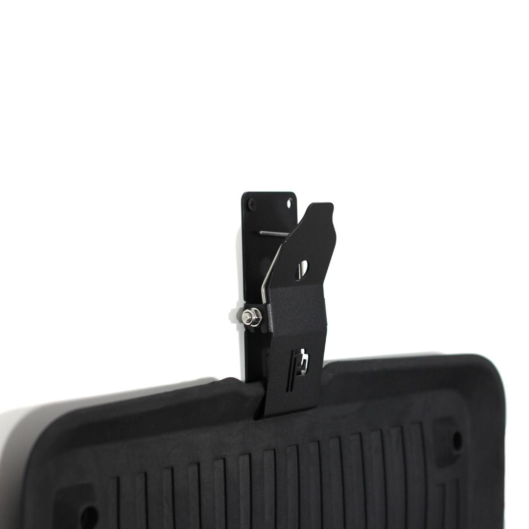 Black Poka Premium mat holder attached to a black car mat on a white background