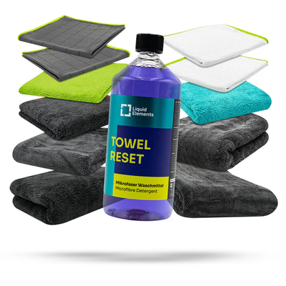 Bottle of 'Towel Reset' detergent with microfiber towels on a white background