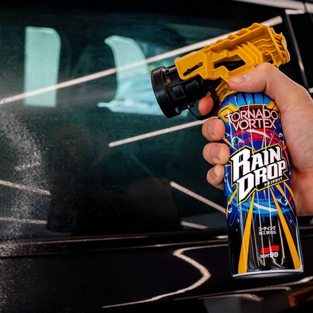 Person holding a Tornado Vortex Rain Drop spray gun against a car window.