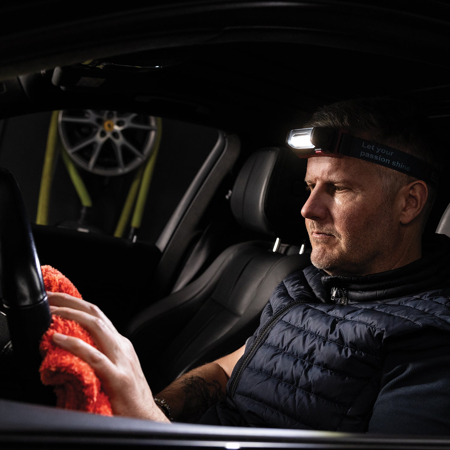 Scangrip I-Match 4  Man cleaning car interior with a headlight and flashlight