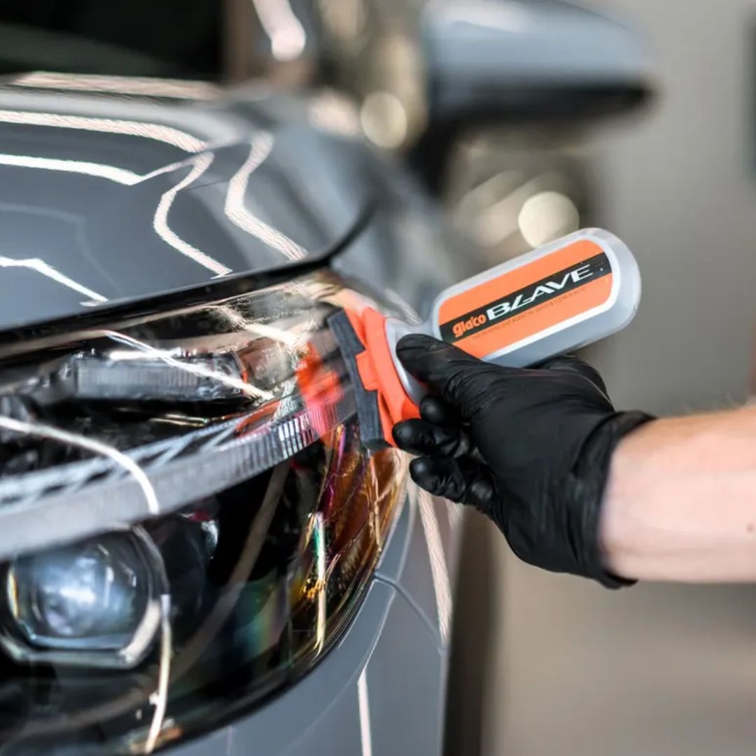 Person using Soft99 Glaco Blave - Glass & Plastic Water Repellent 70ml on a car's headlight