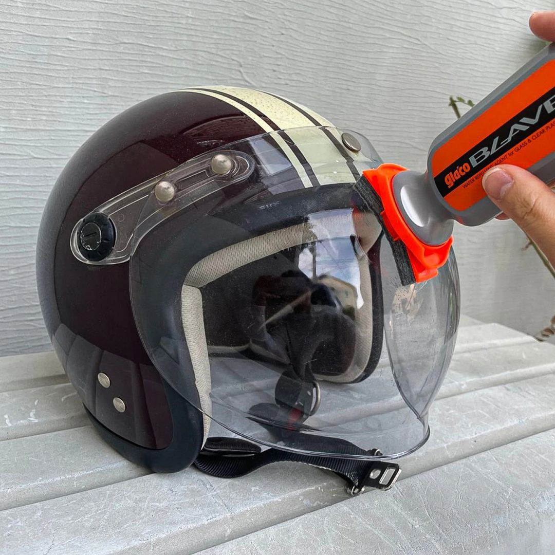Helmet with Soft99 Glaco Blave - Glass & Plastic Water Repellent 70ml being used on a textured wall background