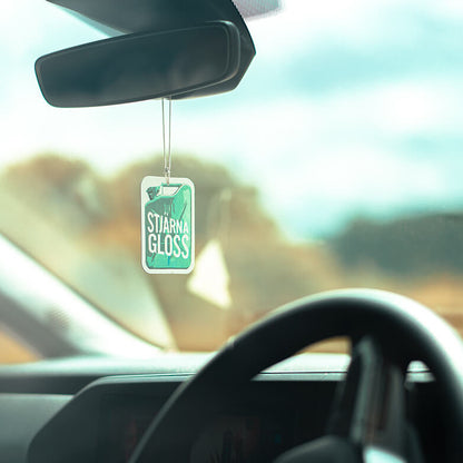 Stjarnagloss Car air freshener hanging from the rearview mirror with a scenic background