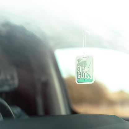 Car interior with a 'Stjarnagloss' air freshener hanging from the rearview mirror.