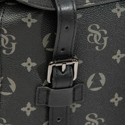 Close-up of a black leather bag with a patterned strap and buckle.