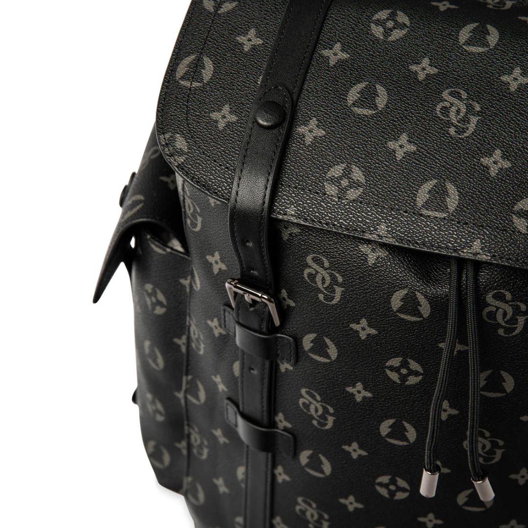 Black backpack with a patterned design on a white background