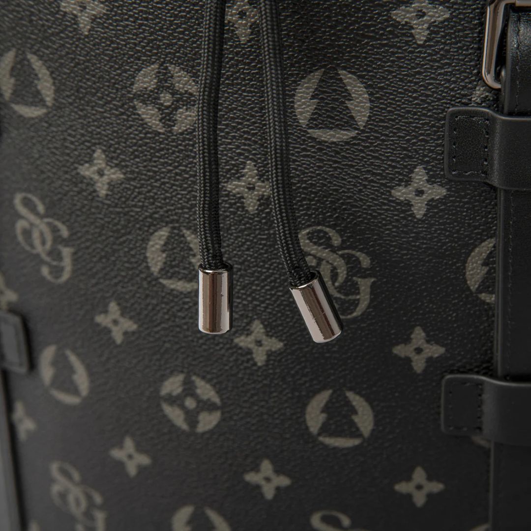 Close-up of a black textured bag with silver zippers and a brand logo.