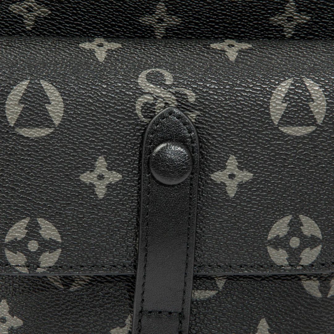 Close-up of a black leather handbag with a brand logo pattern