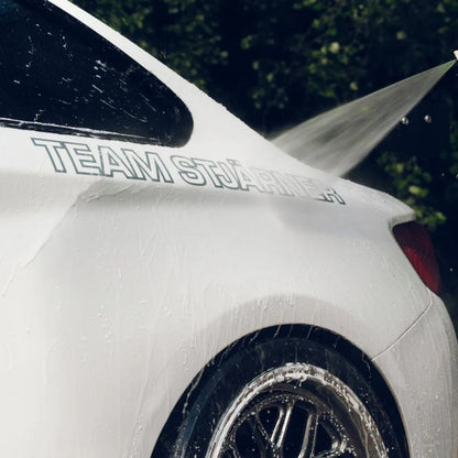 White car being washed with a hose, featuring 'Team Stjarnagloss' decal.