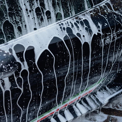 Close-up of a Stjarnagloss Glo foam on a black car surface