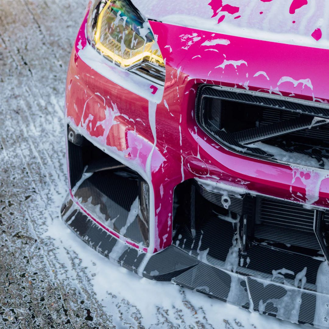 Pink BMW M2 with Stjarnagloss Sno - pH-Neutral Snow Foam on a concrete surface