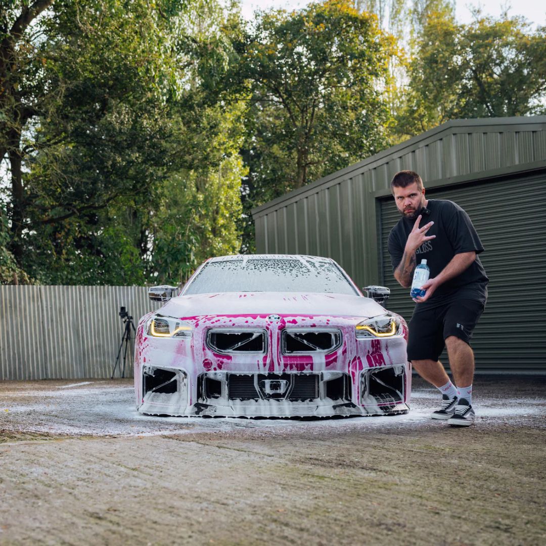 Man standing next to a pink BM2 M2 car with pink and Stjarnagloss Sno - pH-Neutral Snow Foam 