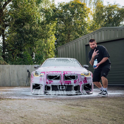 Man standing next to a pink BM2 M2 car with pink and Stjarnagloss Sno - pH-Neutral Snow Foam 