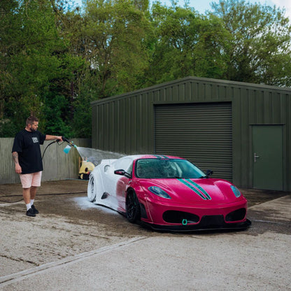 Person using Stjarnagloss Sno - pH-Neutral Snow Foam on front of pink Ferrari