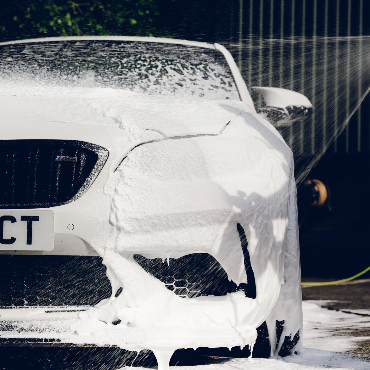 Car being washed with foam on a driveway