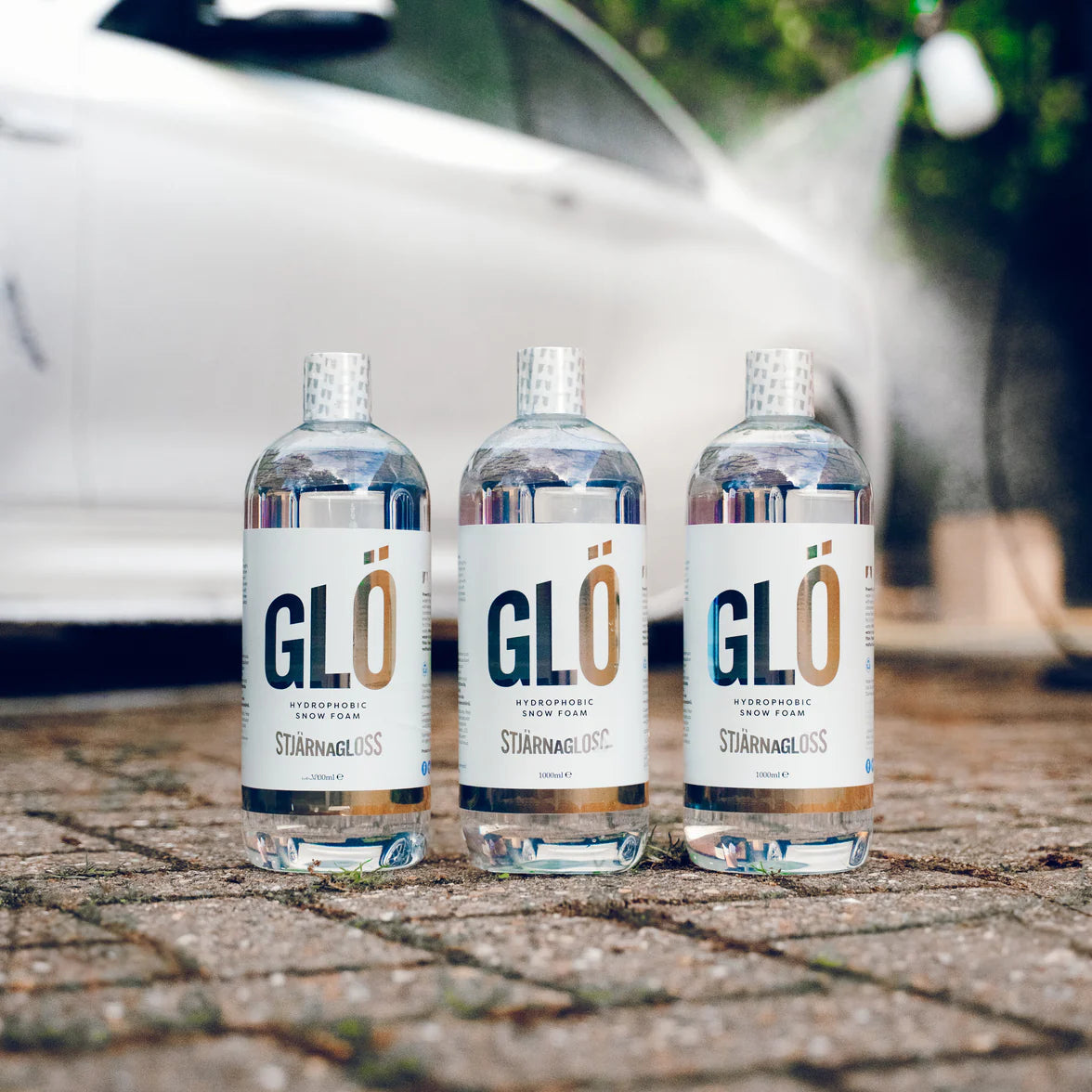 3 bottles of Stjarnagloss Glö with white BMW in the background