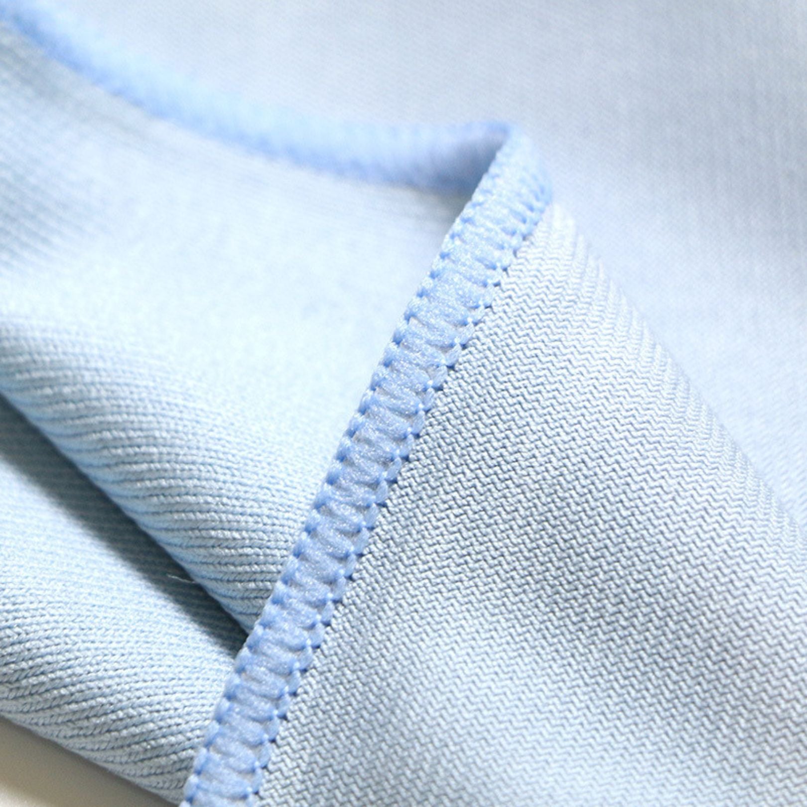 Close-up of light blue glass cleaning microfibre cloth with a textured pattern