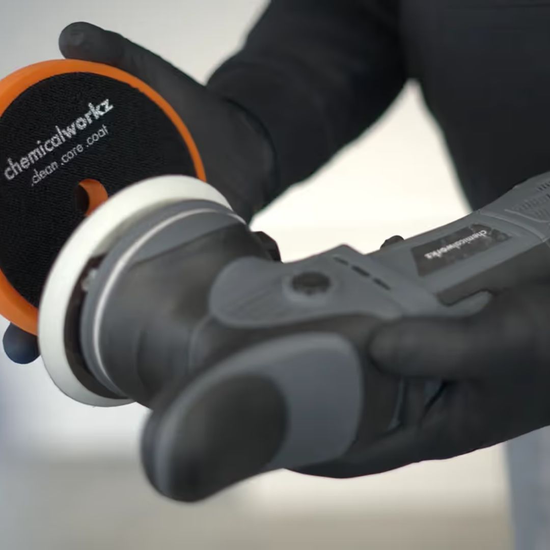 Person holding a polisher with a 'chemicalworkz' pad on a white background