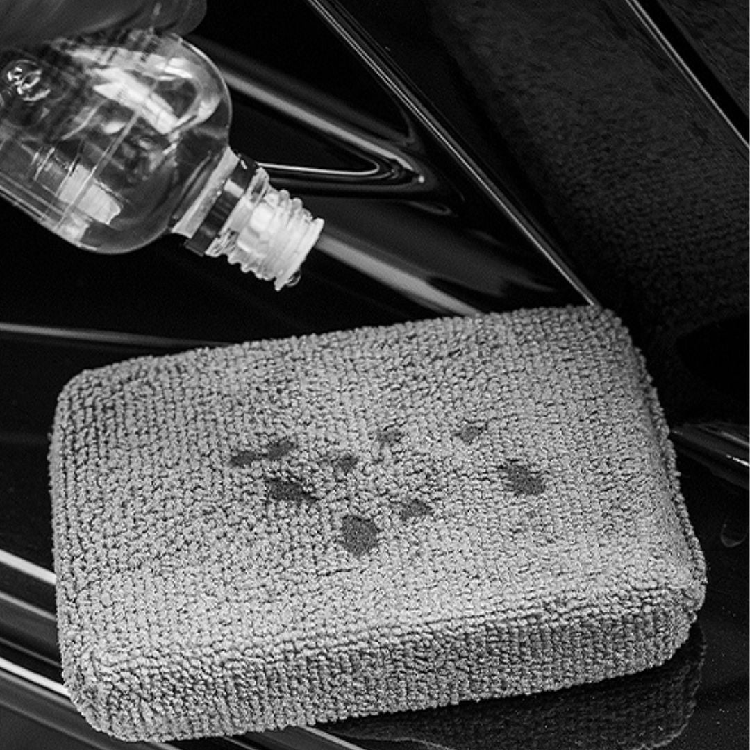 Gray microfiber towel with a brand logo on a car interior background