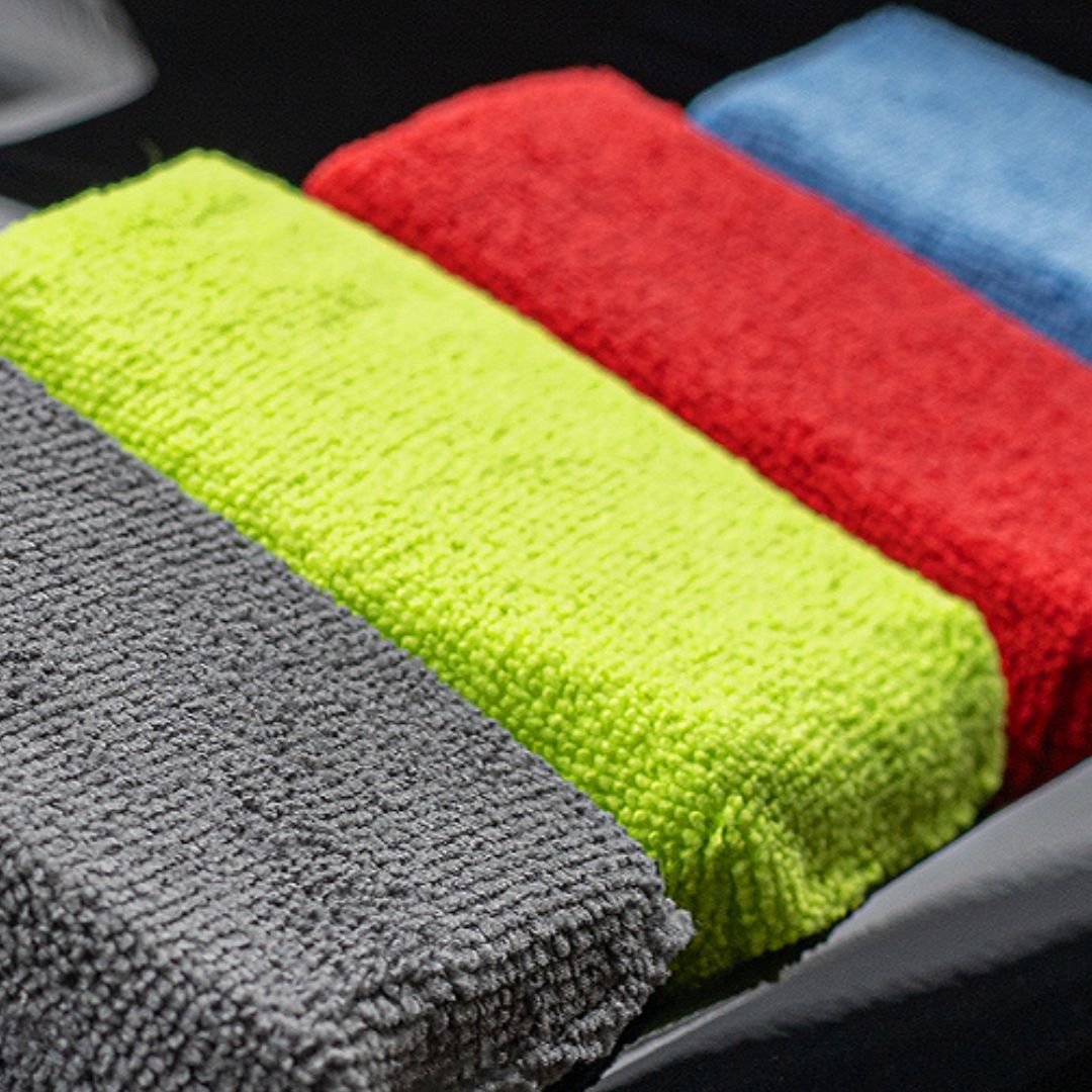 Set of colorful microfiber cloths in green, red, blue, and gray.